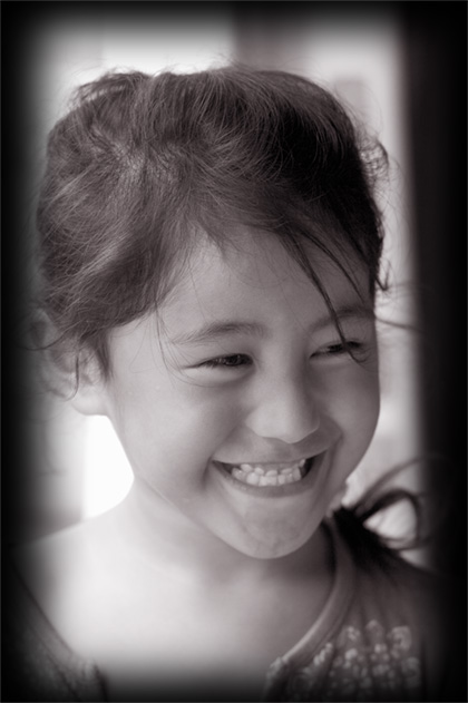 a girl's smiling face with a square frame behind her