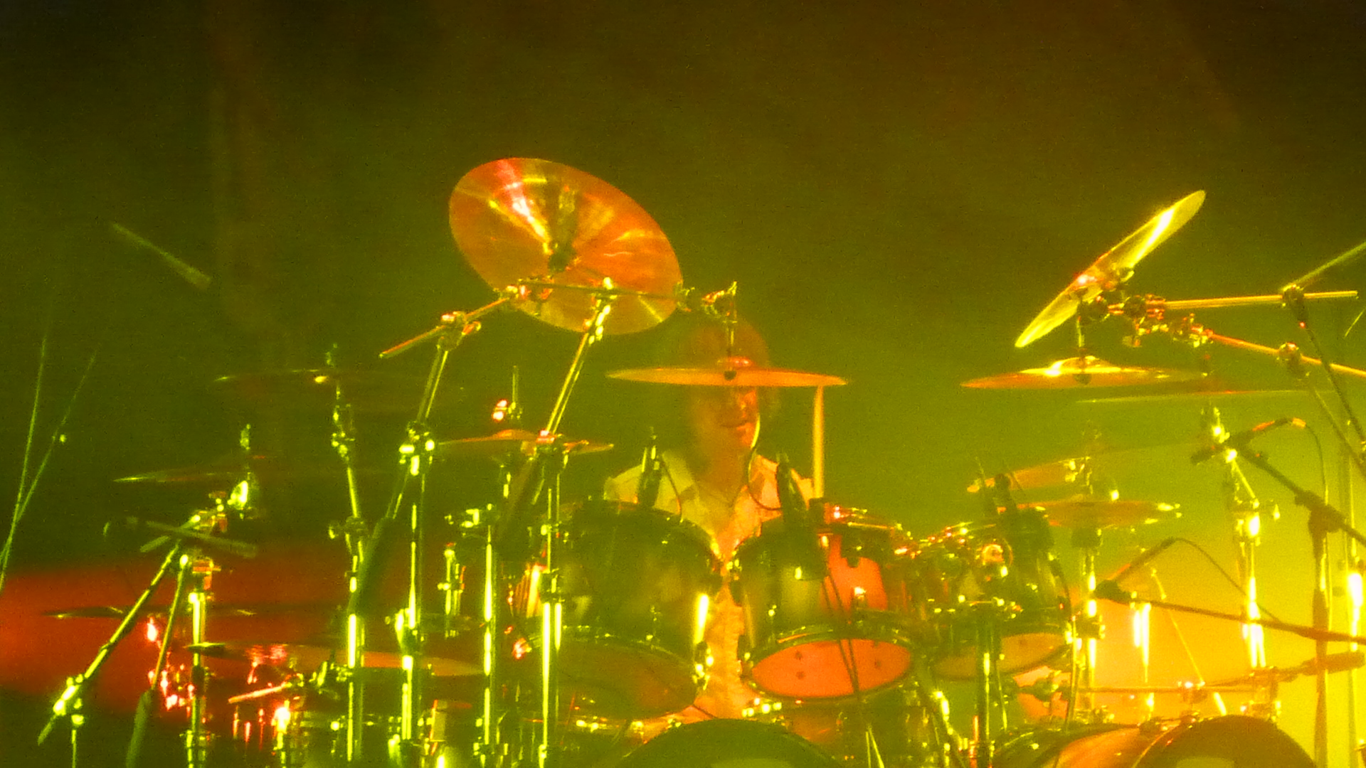 a man holding a microphone up while playing the drums