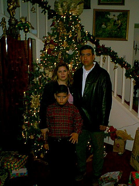 a family with a christmas tree and presents in the room