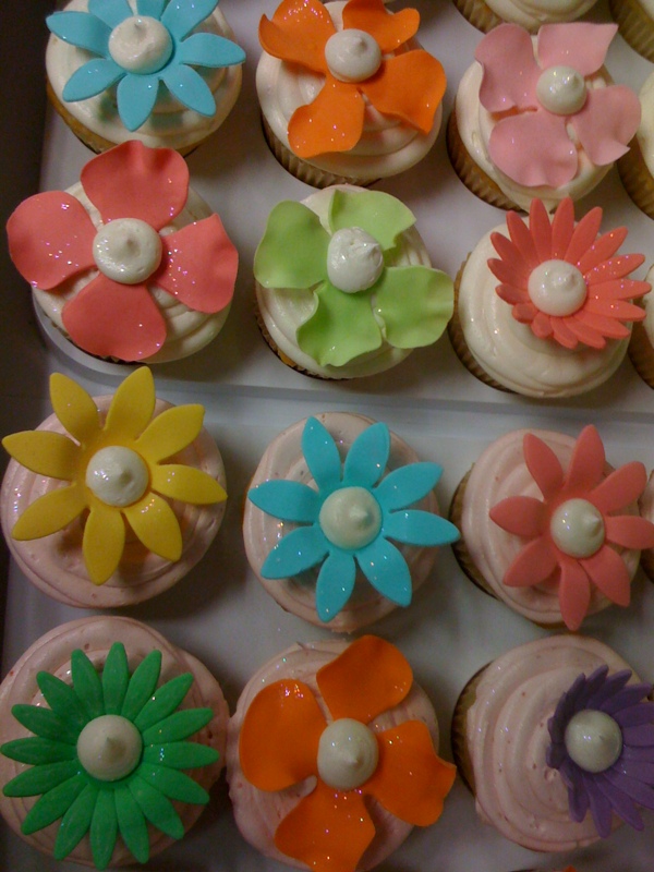 cupcakes decorated with colorful flower decorations and icing