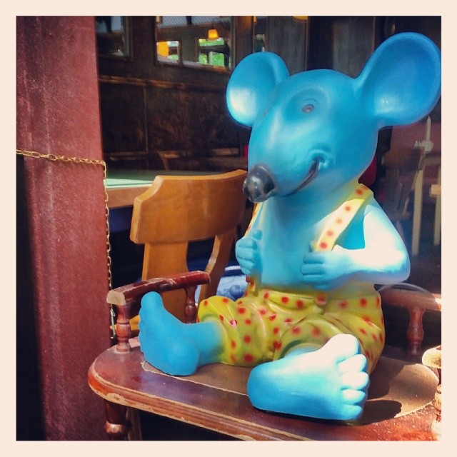 there is a blue statue of a mouse sitting on a table