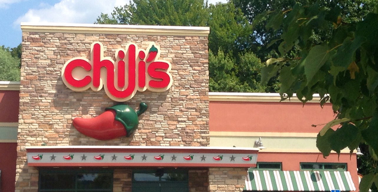the facade of a chili restaurant with a large brick sign