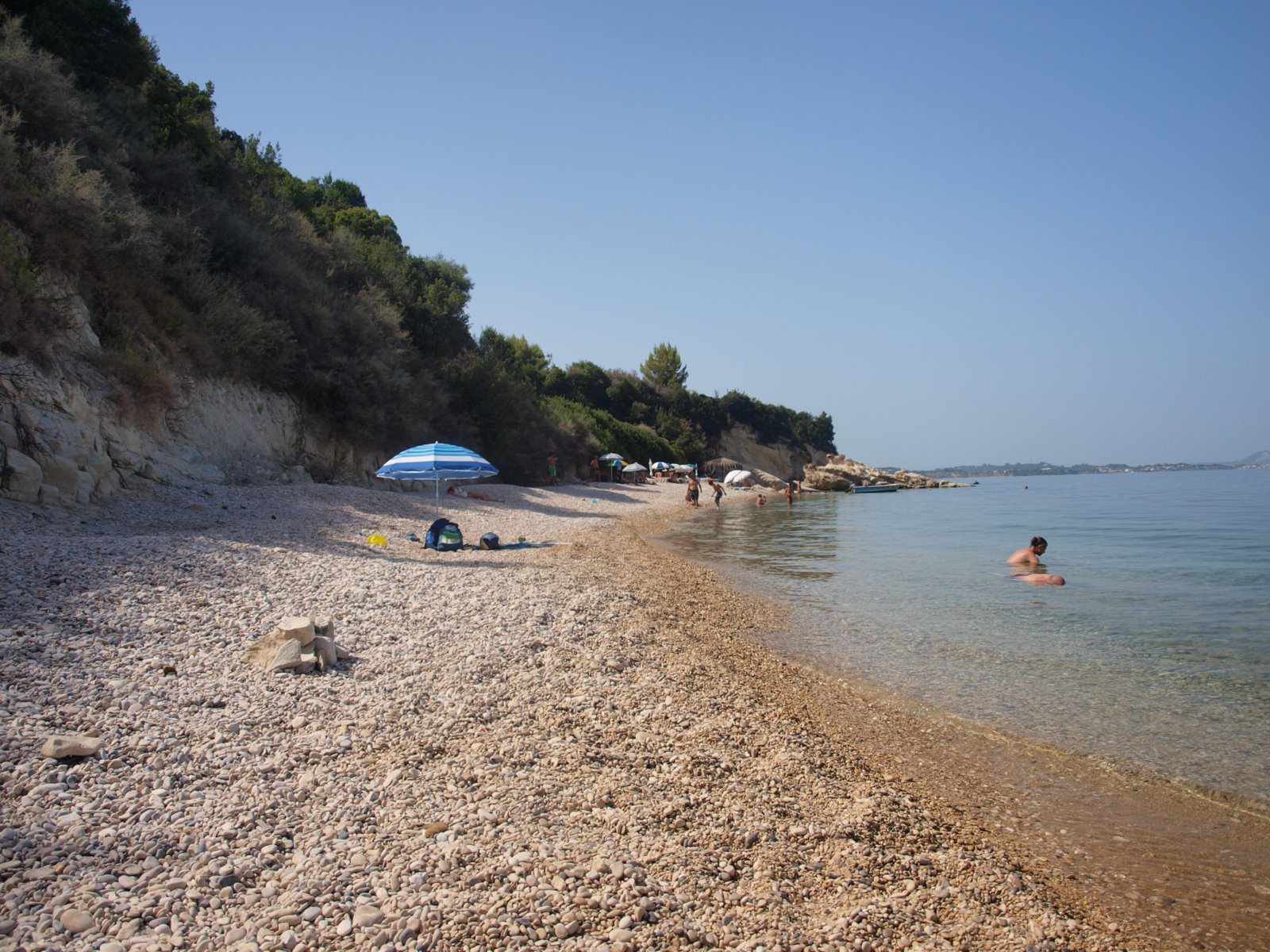 people and dogs are sitting on the beach at a quiet beach