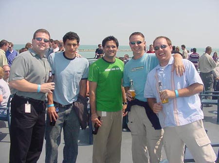 two men standing beside two other guys on a pier at the beach