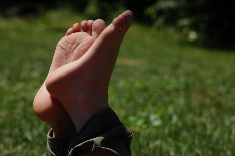 two hands extended open with grass in the background