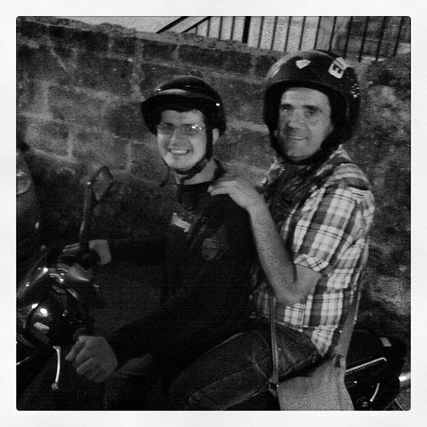 two people with helmets are riding on a motorcycle