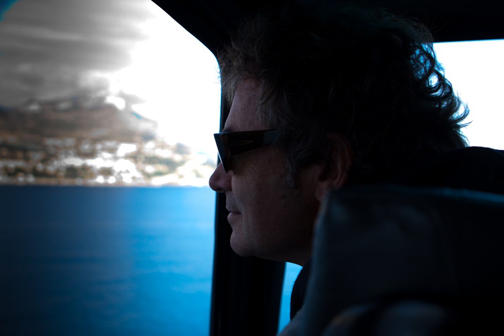 a man in sunglasses sitting in a vehicle looking out the window