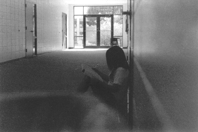 a woman sitting on the floor in an empty room