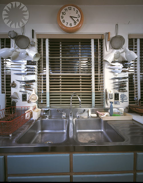 two double sinks in a kitchen next to a clock