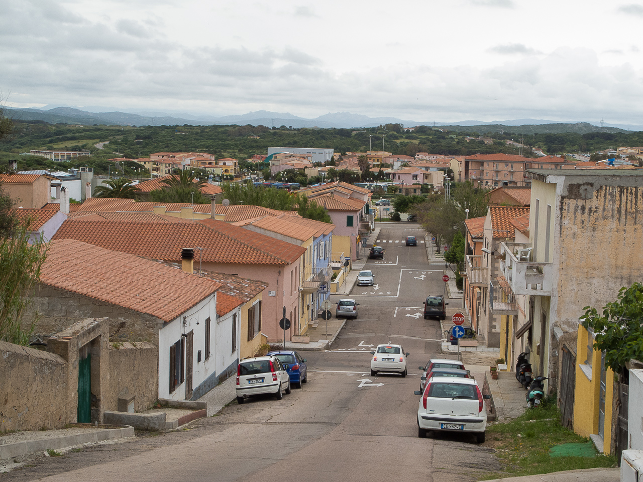 a street with some cars parked along it and some buildings on both sides