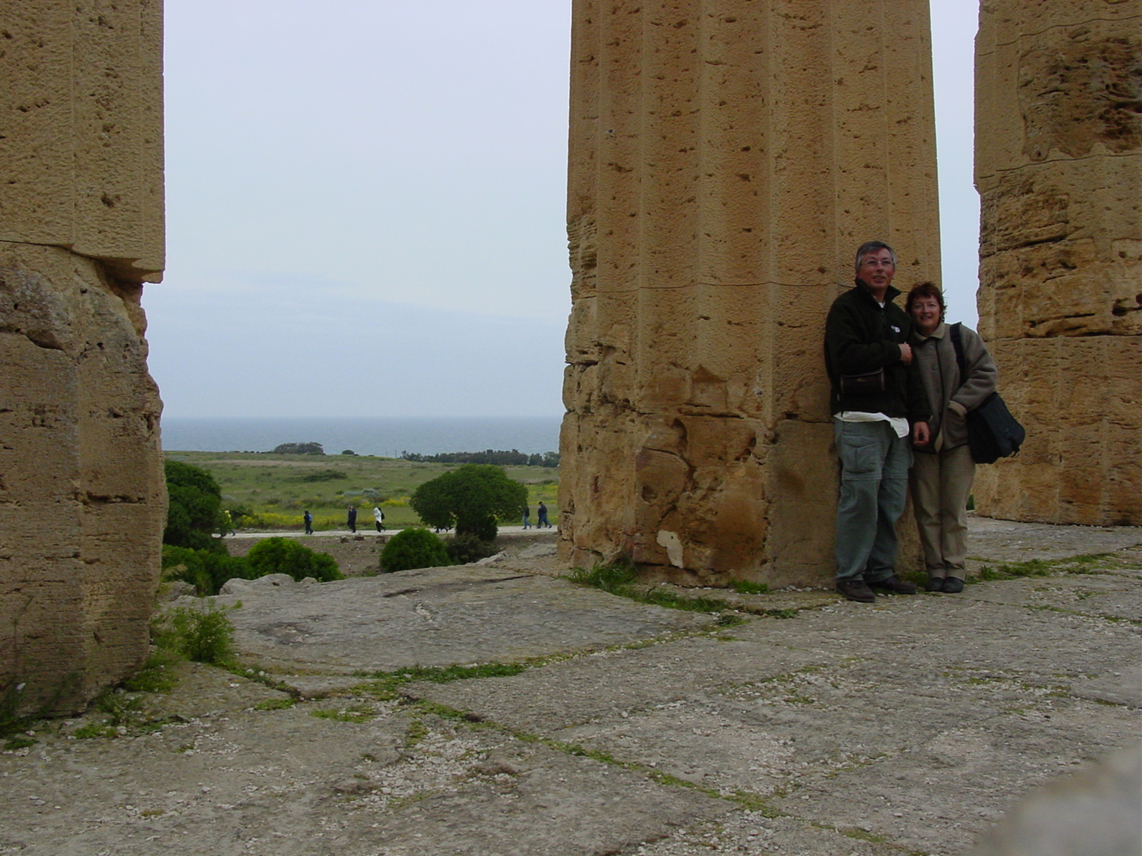 two people standing next to each other near many pillared structures