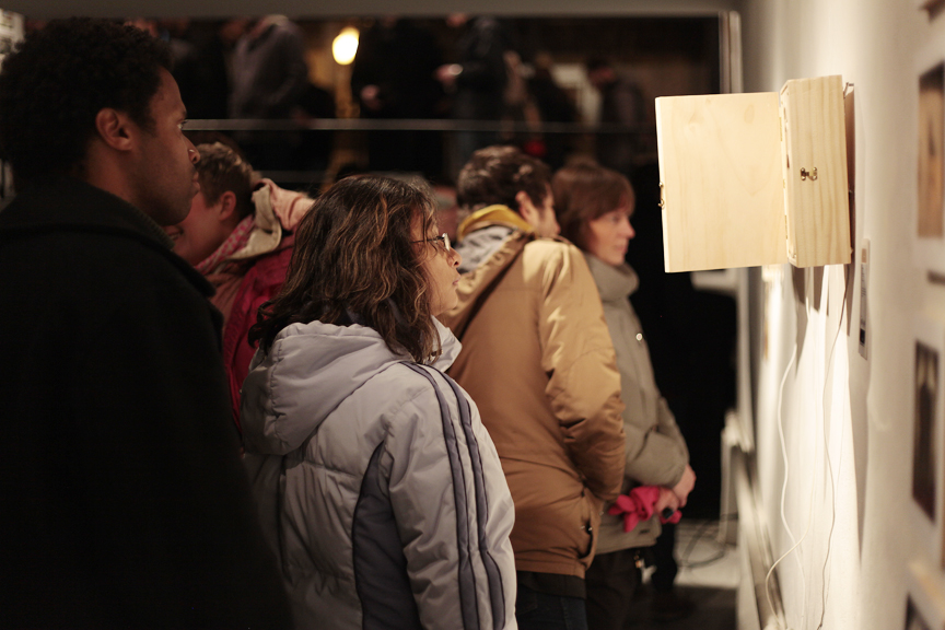 the group of people are standing together looking at art