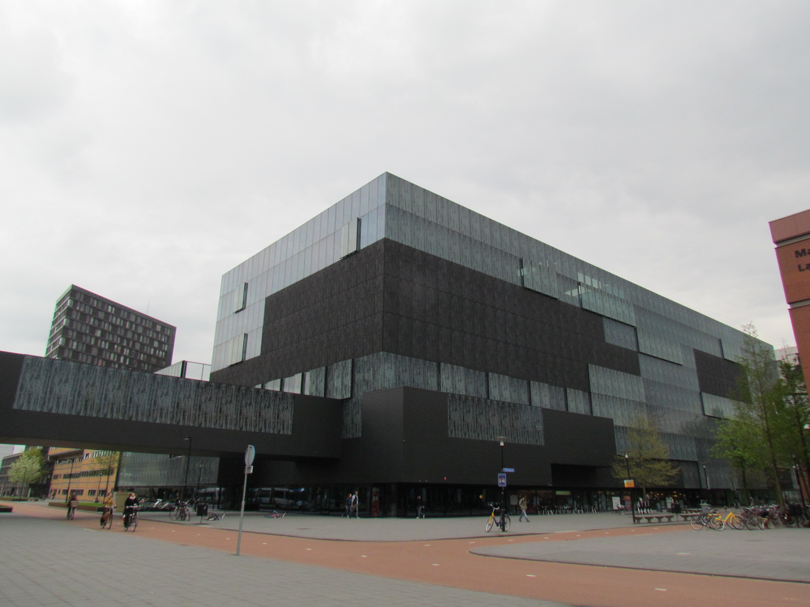 people walking and sitting around in front of a building