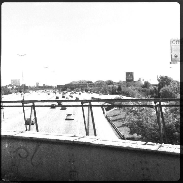 black and white pograph of highway traffic in the middle of the day