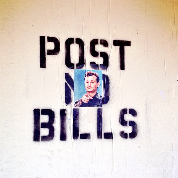 graffiti on a wall stating post no bills