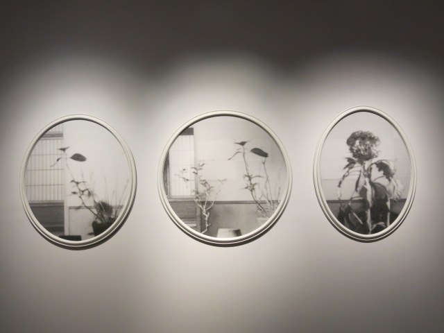 three round mirrors reflecting a black and white po