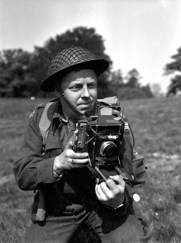 a man holding a camera in an old black and white po