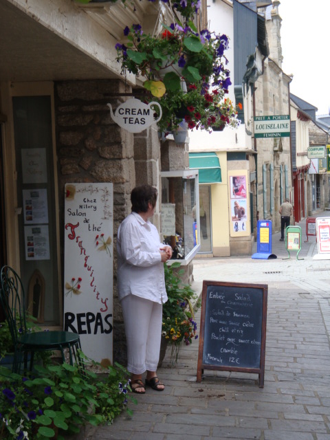 a woman standing on a sidewalk reading her menu