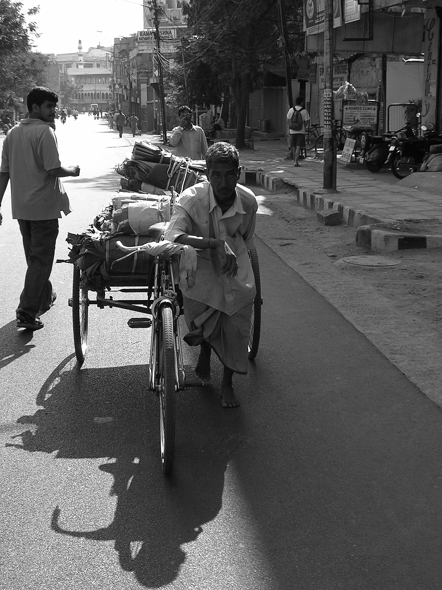 a person hing a wheel chair on a street with pedestrians