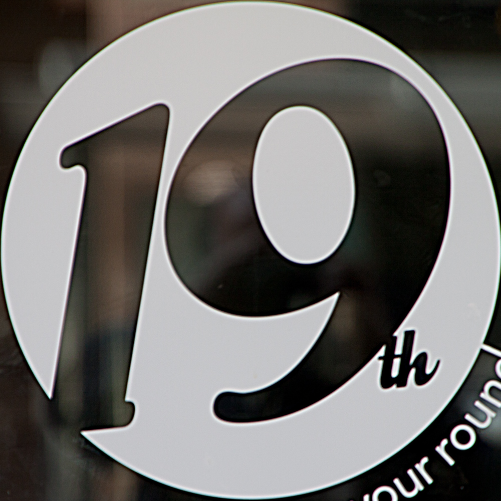 a white sign in a store window shows the logo of the organization