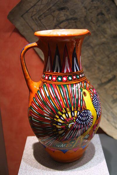 an orange vase on display in a museum