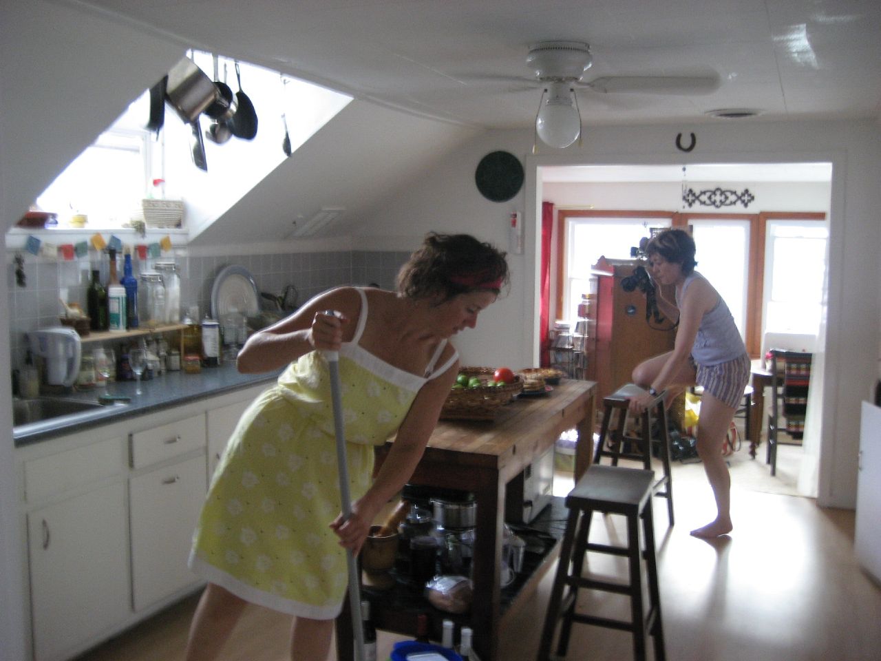 a young woman standing at a wooden table in a kitchen