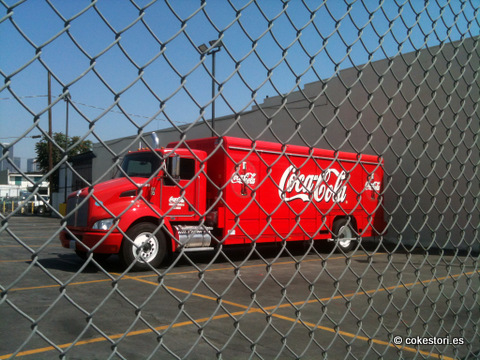 a coca cola truck behind a chain link fence