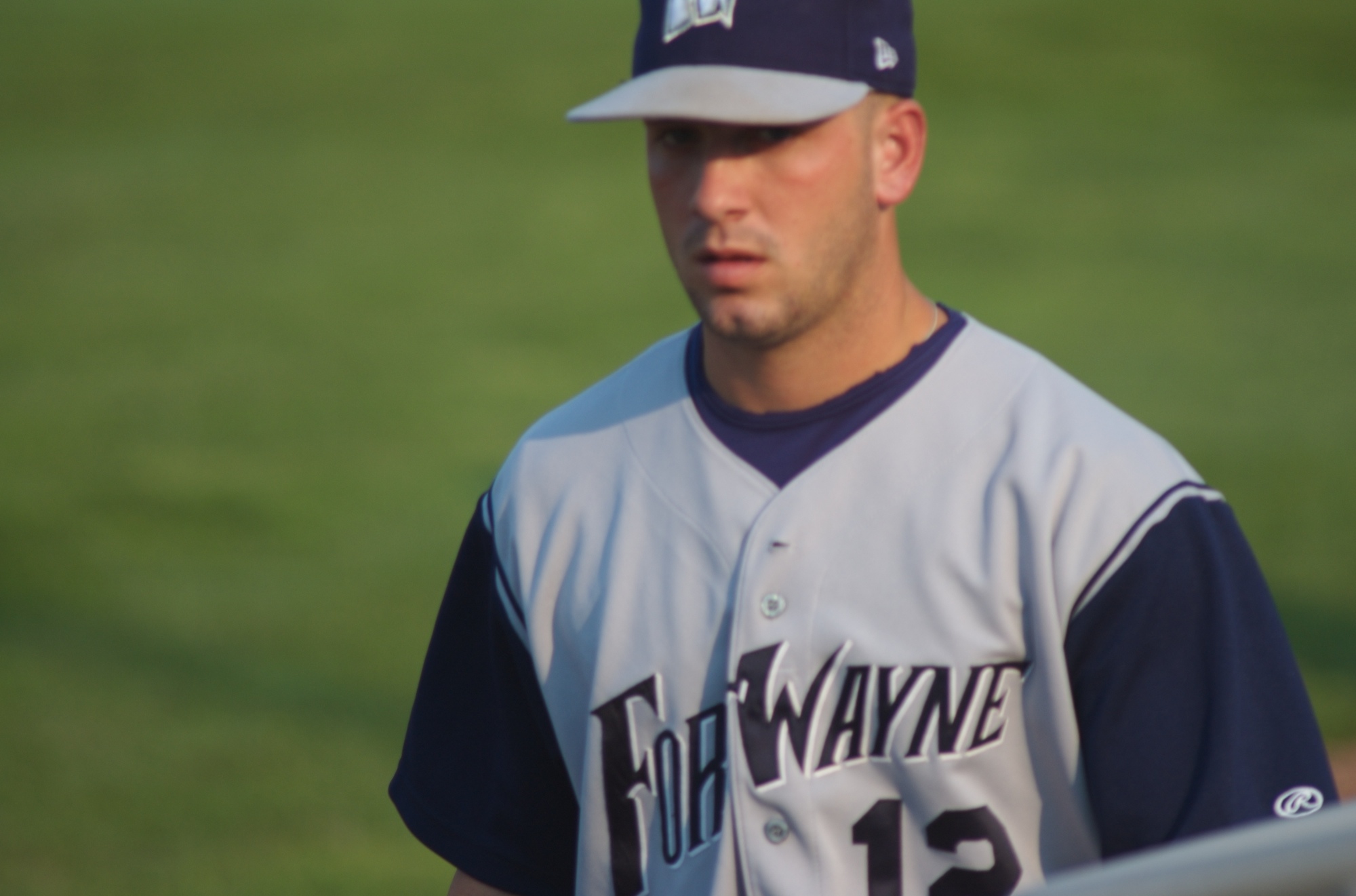 a baseball player in a gray and navy uniform