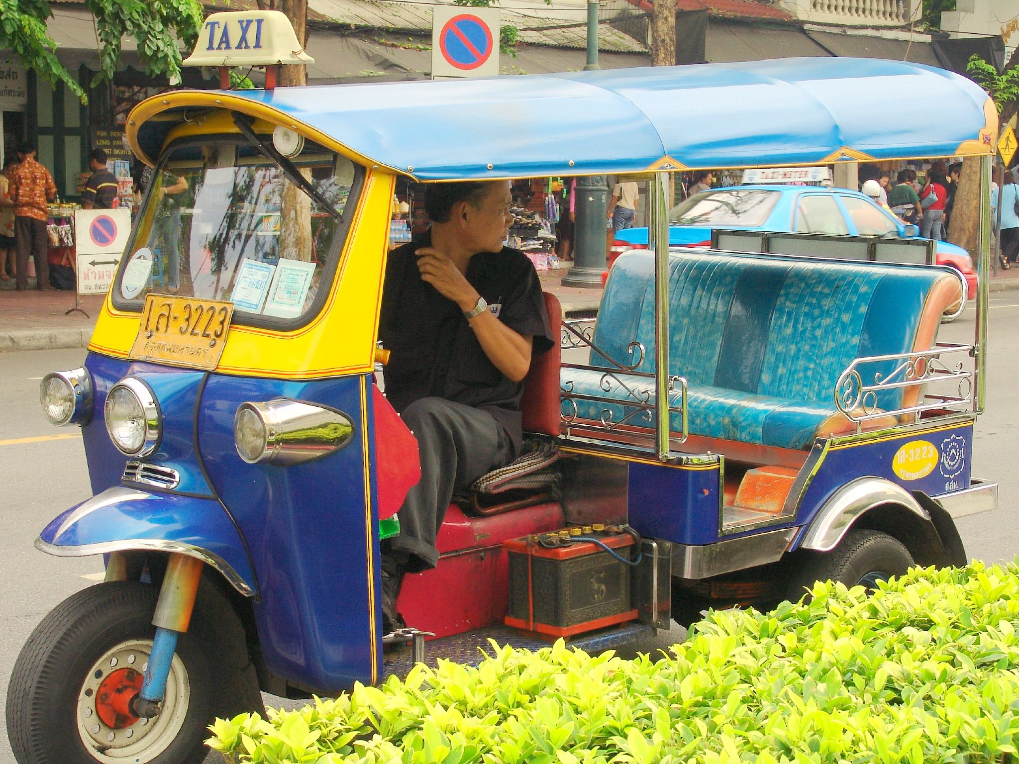 a man sitting in a tuk - tuks is going down the road