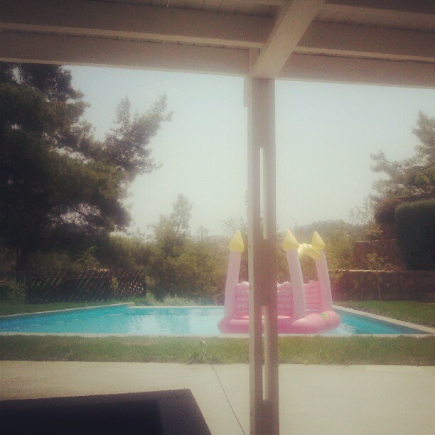 an inflatable swimming pool with pink slide