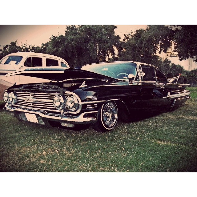 a vintage car parked on top of a lush green field