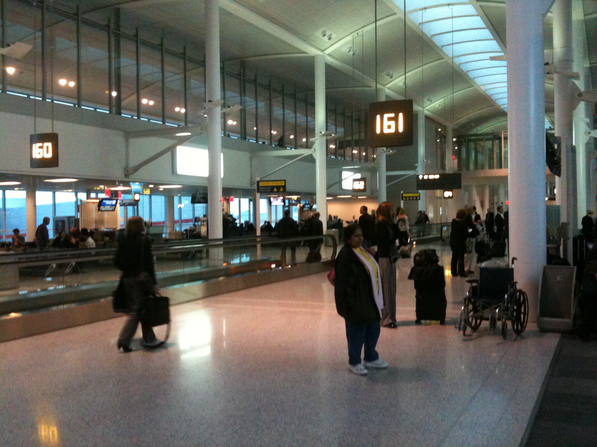 people waiting for luggage at the airport in an airport