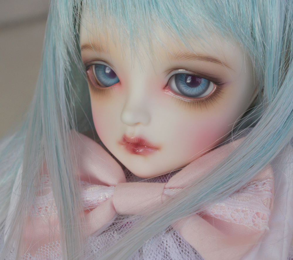 a close up po of a doll with long blue hair
