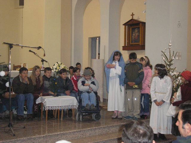 a group of people with their baby being held by them in church