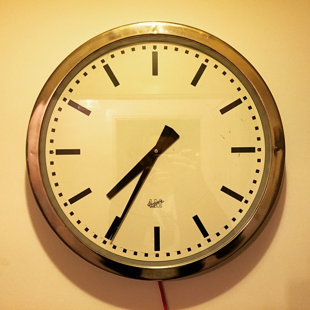 a close up of a clock with red wires attached to it