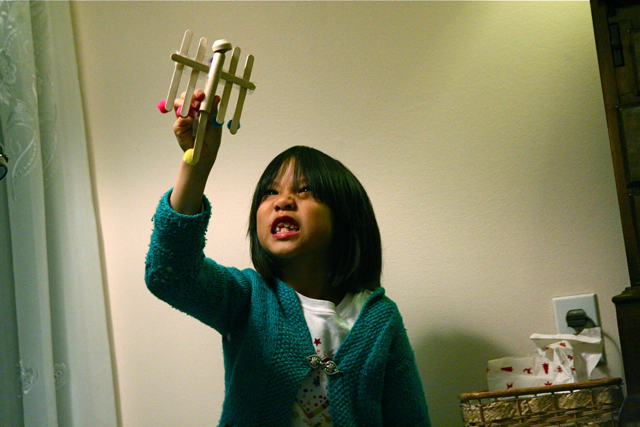 a little girl holding a small airplane in her hand