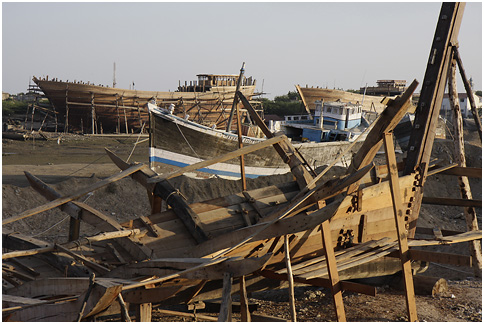 a boat is sitting on some sand and broken wood