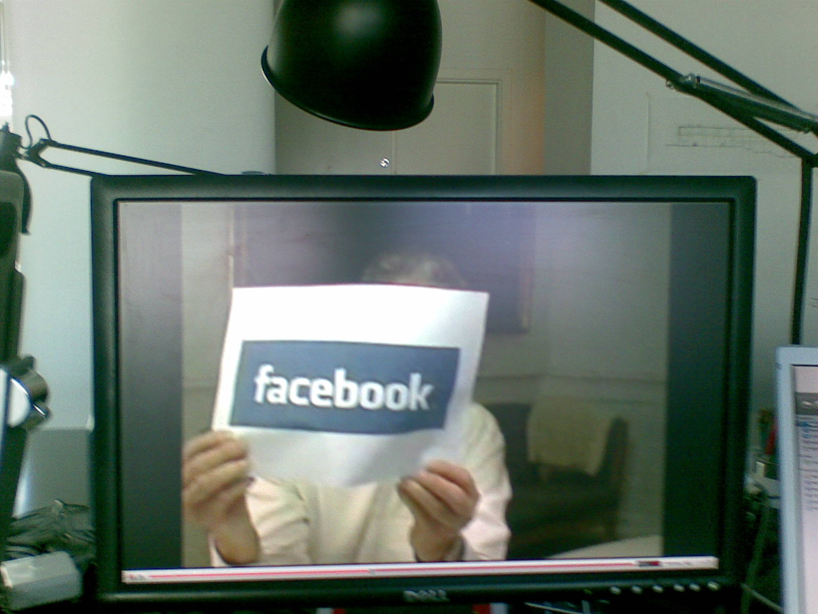 a person is holding up the screen of a facebook logo