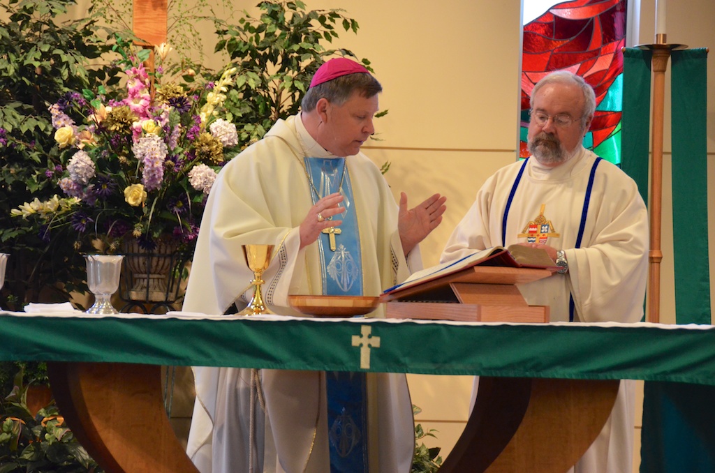 a priest is giving a prayer to another priest at a ceremony