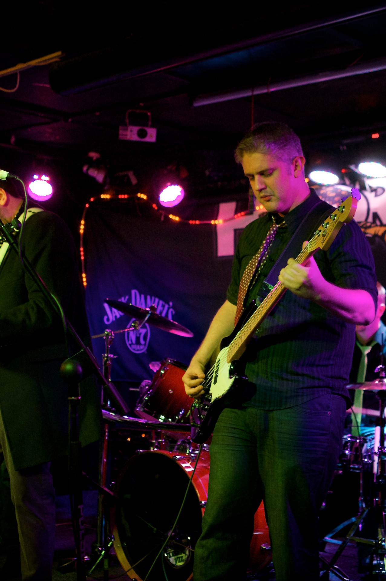 a person playing guitar while other musicians are performing