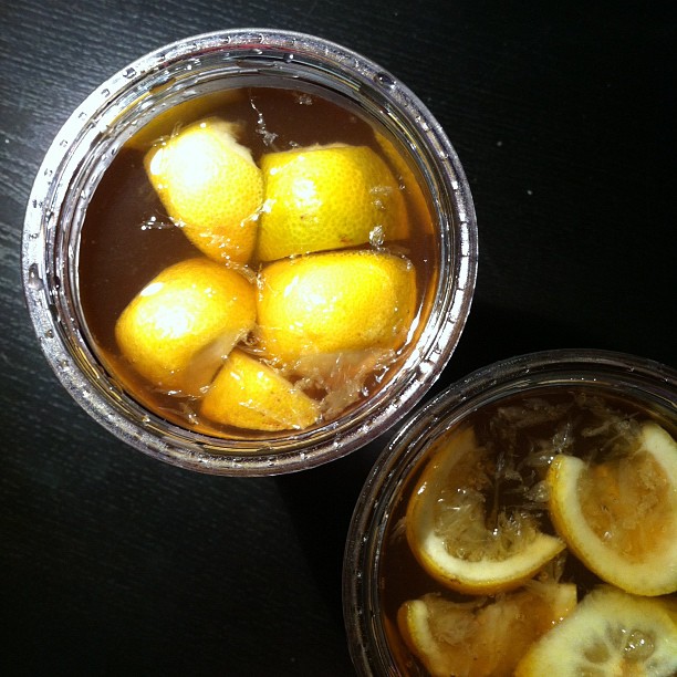 two glasses with water and lemons inside on table