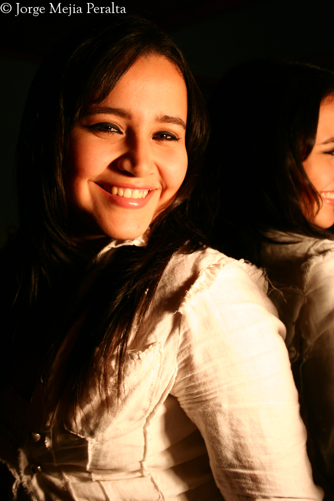 two young women smile while they sit together