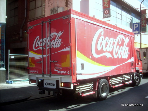 a large coca cola truck on a street