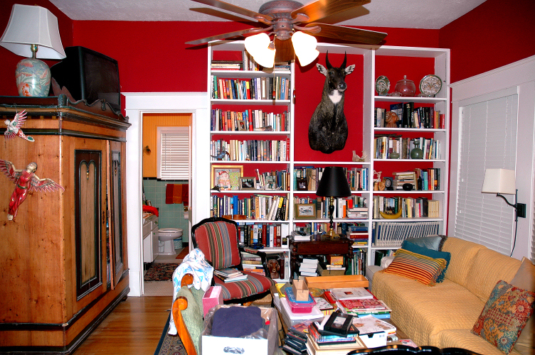 a living room with furniture and a red wall