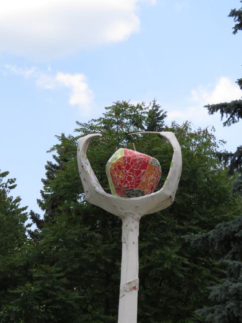a statue of an apple inside of a large round fruit