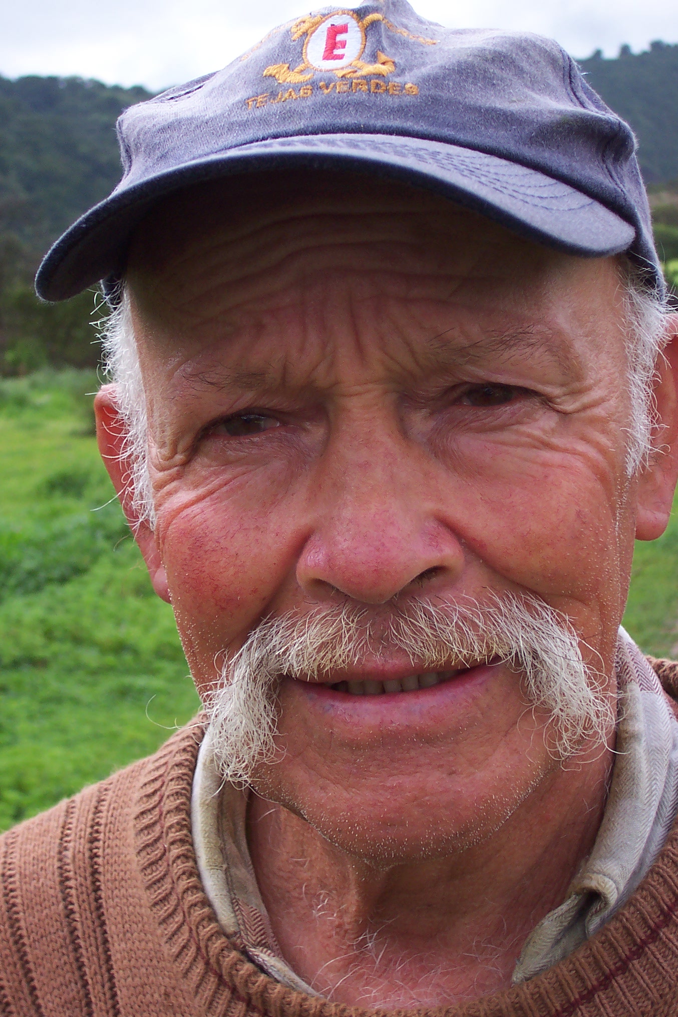 an older man with a goatee wearing a hat