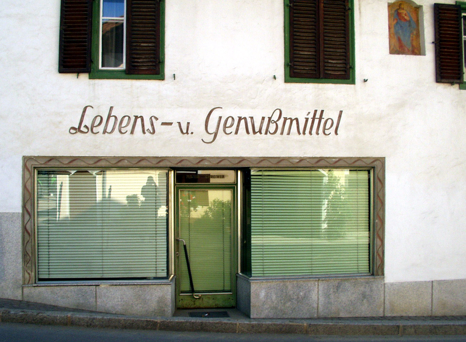 a store front with green windows has the words gerbens - u genusmintell above the windows