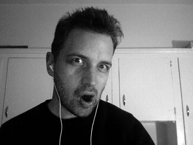 a man making a surprised face while wearing headphones