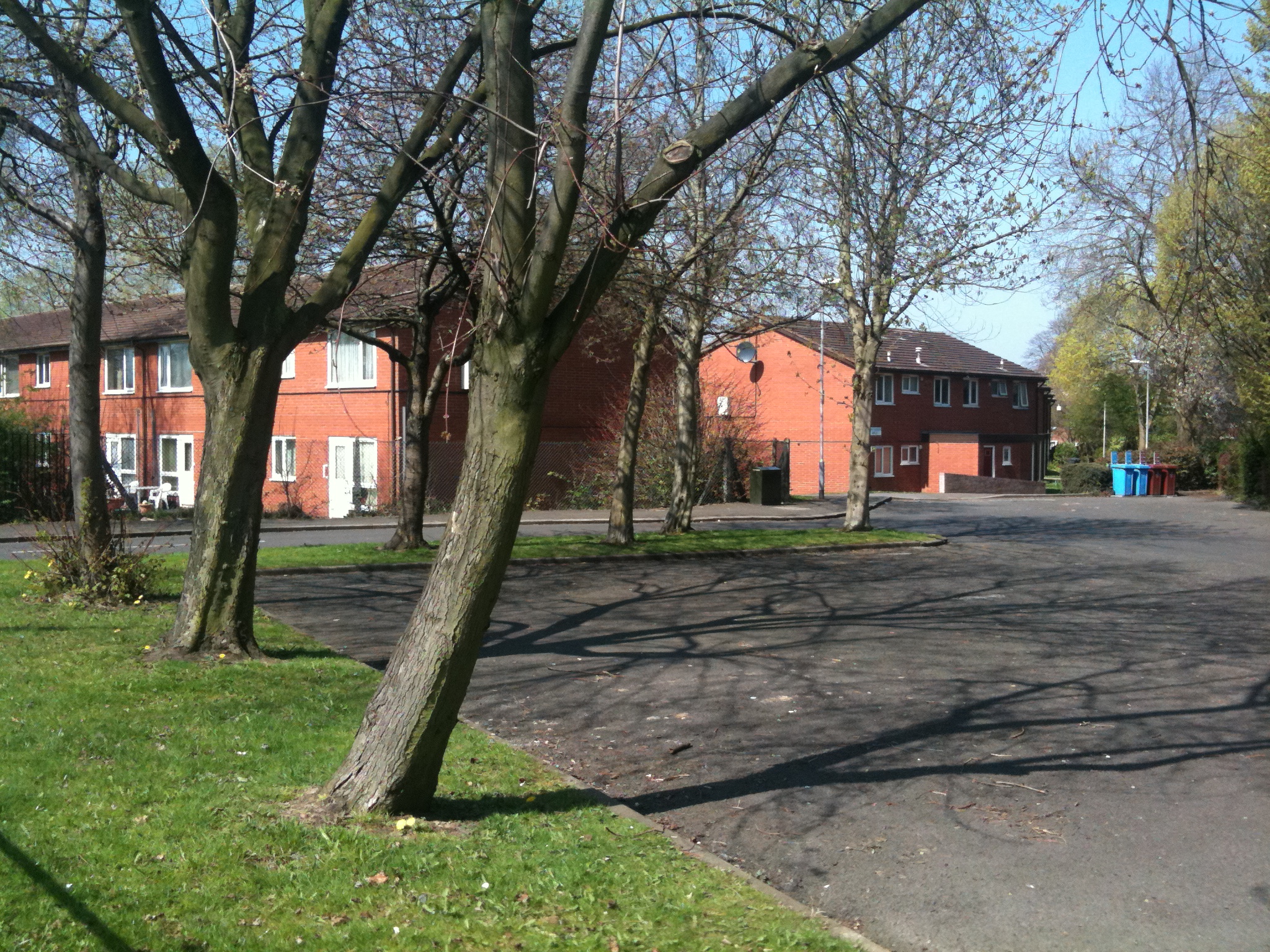 a large driveway with two large brown houses