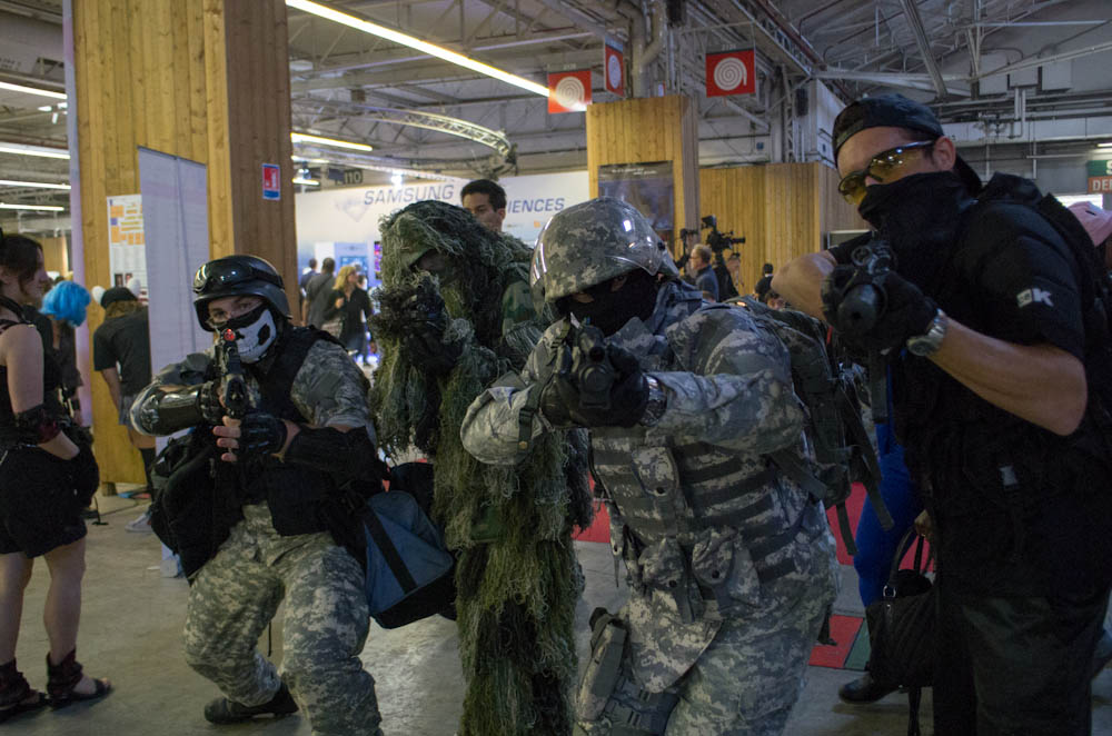 men wearing camouflage paint and helmets talking to each other